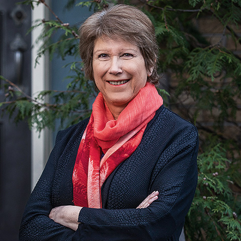 Close-up portrait of a smiling Prof. Anne Gatignol wearing a dark blazer and red scarf